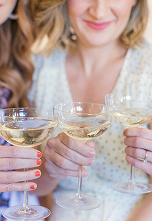 three women holding champagne glasses