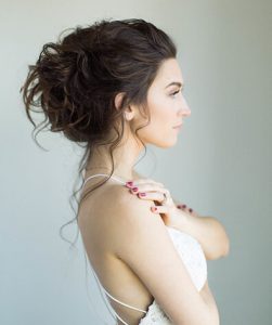 Brunette Model with Tousled updo and loose tendrils falling out of bun