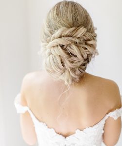 Model in Wedding Gown with Blonde Locks Loosely pulled into twisted low bun with soft tendrils coming out of bun
