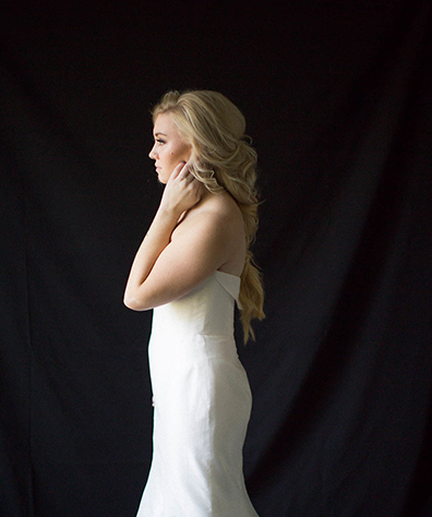 Blonde Model in wedding gown shot from side long fishtail braids loosely pulled together
